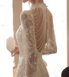 the back of a woman's dress with pearls on it