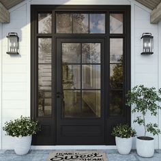 a front door with two potted plants on the side and a welcome mat in front