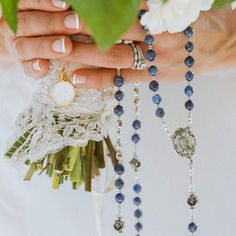 Create a one-of-a-kind heirloom wedding gift for the bride and groom! Include the first names of the bride and groom. Due to the number of beads in a rosary decade, there is a maximum of 10 letters in each name. The standard bead selections are either eggshell white Swarovski crystal pearls ($255 rosary) or beautiful blue kyanite gemstones ($355 rosary). The "Our Father" beads are sterling silver roses to honor Our Lady who is often associated with the flower. The sterling center is the Blessed Blue Gemstone Beads Necklace For Wedding, Silver Necklace With Miraculous Medal For Wedding, Heirloom Blue Necklaces For Weddings, Elegant Handmade Jewelry For First Communion, Elegant Rosary With Polished Beads As Gift, Elegant Rosary With Polished Beads For Gift, Elegant Adjustable Rosary With Polished Beads, Elegant Gift Rosary With Polished Beads, Elegant Beaded Rosary For Gift