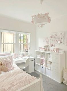 a bedroom with white furniture and pink decorations on the walls, along with a large window