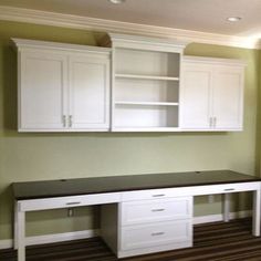 an empty room with white cabinets and drawers