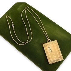 "Description: Beautiful antique Art Deco style gold filled locket that features pinstriping and a monogram of FWM on the front. This is a rather large rectangular locket that has a swirled leafy frame etched all around the vertical striped etched lines on the front. There is a rectangular cartouche on the top left side that has the letters FWM monogramed inside it in a bold font. This locket was designed to hold three photos - one on each side and one in the middle frame holder with an oval open Gold Rectangular Keepsake Necklace, Gold Rectangular Necklace For Keepsakes, Victorian Gold Rectangular Necklace, Victorian Rectangular Gold Necklace, Victorian Engraved Rectangular Necklace, Gold Etched Rectangular Pendant Jewelry, Vintage Yellow Gold Necklace With Rectangular Pendant, Gold Rectangular Jewelry Keepsake, Gold Rectangular Keepsake Jewelry