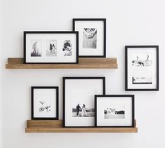 four black and white pictures are hanging on the wall above wooden shelves with wood trim around them