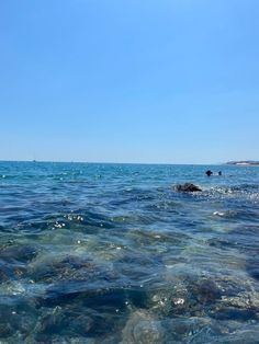 the water is very clear and blue with some rocks in it's foreground