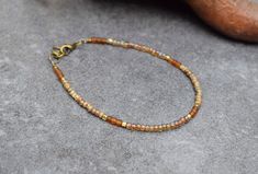 Dainty bohemian bracelet with rustic tiny beads and warm brown colors.  A lovely piece that is easy to combine and perfect to add to your everyday outfit. She will also make a unique gift for the Holidays! Here you find the matching necklace: https://etsy.me/3iqeBDN I mixed opaque and translucent colors to create a color block design. Note that the beads in this bracelet have an earthy Picasso finish, giving them an aged appearance. In between I used irregular frosted brown beads that add to the rustic look. The tiny gold brass cube beads are handmade in Ethiopia. They create a subtle bohemian sparkle. - The bracelet is finished with an extension chain of approx. 1 inch (3 cm) - I used high quality Miyuki glass seed beads of 3 mm (size 8/0). Precision-made in Japan, and among some of the f Brown Beaded Bracelets With Gold Beads As Gift, Gift Brown Beaded Bracelets With Gold Beads, Brown Rustic Beaded Bracelets With Round Beads, Earthy Brown Beaded Bracelets With Round Beads, Brown Beaded Bracelets With Round Beads For Festivals, Bohemian Brown Friendship Bracelets With Round Beads, Hippie Style Beaded Friendship Bracelets In Brown, Brown Beaded Bracelets For Festival, Hippie Style Brown Bracelets For Gifts