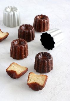 several bundt cakes on a white surface next to a black and white cake server