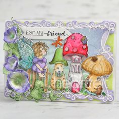 a handmade card with an image of two fairy houses and mushrooms on the front