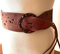 Vintage fashion belts wide brown leather fringed wardrobe accessories cowgirl ITEM DESCRIPTION: Offering this wide brown leather fashion belt. circa estimated 1980s-2000's This adjustable fringed belt features a stencilled leather strap with Tiger's Eye 'stones' (faux?) circling the big round buckle.  The inside belt strap is marked: "L. Leather China".  MEASUREMENTS: This classic hip belt measures approximately 37 1/2 inches full length (including buckle but not including fringe) and 3 inches w Antique Brown Belt Buckle For Festival, Brown Antique Buckle Belt Buckles For Festival, Adjustable Brown Belts For Festival, Adjustable Brown Belt For Festival, Bohemian Brown Belt For Festival, Adjustable Brown Corset Belt With Matching Belt, Bohemian Brown Belt Buckles For Festival, Vintage Brown Corset Belt For Festivals, Vintage Brown Corset Belt With Belt Loops