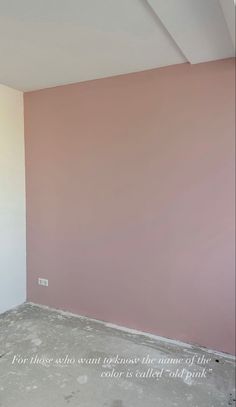 an empty room with pink walls and white trim on the walls, is being painted