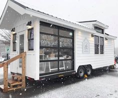 a small white house sitting on top of snow covered ground