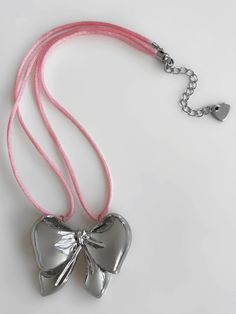 An accessory this irresistible is hard to come by. Meet the 'JENNIE' necklace - featuring our exclusive pink satin cord and a precious bow pendant, you'll never want to take this piece off! Made with genuine satin cord and stainless steel pendant. Waterproof & rust-free. Available in lengths 14", 15", 16", 18". All lengths include a 2" extension chain. Model is wearing 15". This is an exclusive 549 piece with very limited quantities. Handmade with love in Los Angeles. Adjustable Silver Necklace With Ribbon, Silver Adjustable Necklace With Ribbon, Silver Jewelry With Satin Bow For Party, Silver Party Jewelry With Satin Bow, Pink Bow Necklace For Party, Cute Pink Jewelry, Adjustable Silver Necklace With Bow, Silver Jewelry With Satin Bow As Gift, Silver Jewelry With Satin Bow For Gifts