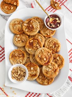 there are many cookies on the plate and some dipping sauces in small bowls next to them