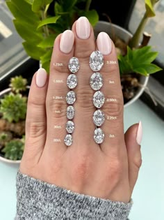 a woman's hand with five diamond rings on her fingers and one ring in the middle