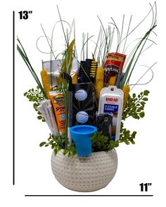 an arrangement of golf items is displayed in a white vase with green grass and blue cup