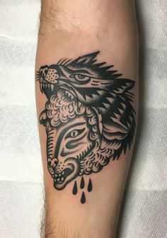 a black and white tattoo on the leg of a man with a wolf's head