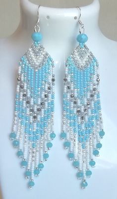 a pair of blue and white beaded earrings on a mannequin headdress