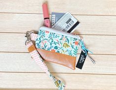 This mini pouch measures 5 by 4 inches. It comes with a coordinating wristlet/key fob. Alligator clasp is sturdy, but makes it easy to hook on keys and other necessities.  Pouch has a faux leather bottom and is lined with coordinating cotton fabric.  Mini pouches are perfect for holding your essentials. Change, cash, credit cards, AirPods, and a chapstick.  Don't see what you're looking for? Send me a message and we can create a custom pick you'll love! Please note, fabric design placement may differ than pictured. Airpod Holder, Mini Zipper Pouch, Headphone Holder, Mini Pouch, Mini Pouches, Purse Pouch, Key Fob, Zipper Pouch, Credit Cards