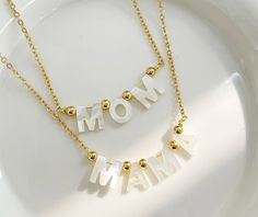 Whether it's MOM or MAMA, whatever you call her, these 14k gold plated necklaces are a perfect gift to say I Love You this Mother's Day, or any day. Cheap Pink Charm Necklaces For Mother's Day, Handmade White Name Necklace For Mother's Day, White Pendant Necklaces For Mother's Day, Handmade White Necklace For Mother's Day, White Pendant Necklace For Mother's Day, Adjustable White Necklace - Gift For Mom, Adjustable White Necklaces As A Gift For Mom, White Necklace For Mother's Day Gift, Adjustable White Necklace As A Gift For Mom