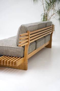 a couch that is made out of wood and has a cushion on it's back