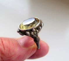 This is a lovely antique gemstone ring. It has been made in the Art Nouveau Style and could actually come from that era but its exact age is unknown. It shows signs of age with details of this below and I have cleaned areas that needed it.  It is made from solid sterling silver, marked sil and has an ornate floral and leaf design on the shoulders and running around the setting. It is bezel set with a faceted golden quartz gemstone and depending on the light, it displays paler and deeper shades o Vintage Wedding Moonstone Cabochon Ring, Vintage Cabochon Moonstone Ring For Anniversary, Vintage Round Moonstone Ring, Vintage Gold Birthstone Ring With Bezel Setting, Vintage Moonstone Round Ring Gift, Vintage Moonstone Ring Gift, Vintage Round Moonstone Ring Gift, Vintage Moonstone Ring As Gift, Vintage Moonstone Birthstone Ring As A Gift