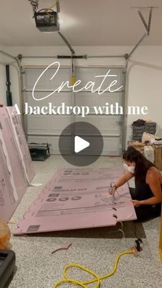 a woman is working on a large piece of pink paper with the words create back drop with me