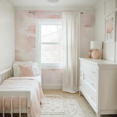 a bedroom with pink and white wallpaper, a bed in the foreground and a window on the far side