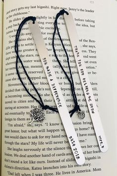 two bookmarks that are sitting on top of an open book