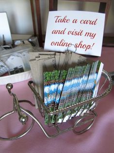 a basket filled with lots of cards on top of a pink tablecloth covered table