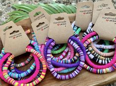 several different colored bracelets sitting on top of a wooden table