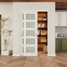 an open door in the middle of a kitchen with wooden floors and white cupboards