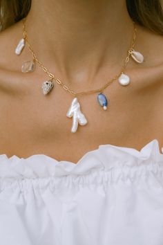 Our Mana necklace is your summertime vacay staple. Drift away to palm lined beaches, collecting shells, balmy summer nights & midnight swims. Paired beautifully with fresh sun-kissed skin & your favorite all white outfit. - 18k gold filled chain - Hand selected luminous freshwater baroque pearls - Lapis Lazuli - Quartz crystal - Mixed shells - Gold filled wire - Approx 16 inches end to end Gold filled jewelry is easily 100 times thicker compared to common gold plating & lasts just li Gold Ocean-inspired Charm Necklaces For Summer, Ocean-inspired Gold Charm Necklaces For Summer, Dainty Shell Charm Necklace For Beach, Gold Ocean-inspired Necklaces For Beach Season, Dainty Strand Jewelry For The Beach, Dainty Strand Jewelry For Beach, Ocean-inspired Gold Necklaces For Vacation, Handmade Dainty Jewelry For The Beach, Ocean-inspired Necklaces For Summer Gifts