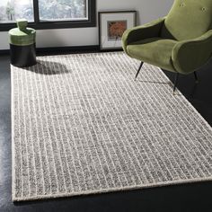 a modern rug with black and white lines on the floor in front of a window