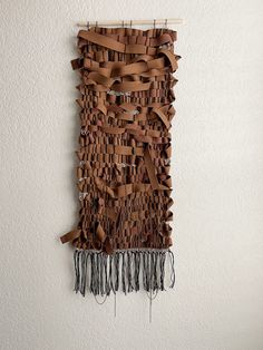 a wall hanging made out of brown leather strips