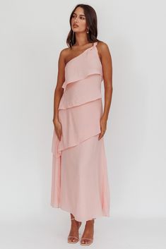 a woman wearing a pink dress with one shoulder and tiered layers on the bottom