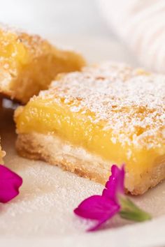 two pieces of lemon bars on a plate with flowers