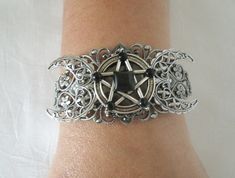 This beautiful silver plated filigree cuff bracelet has a silver plated triple moon design and a pewter silver pentacle with obsidian settings. Adjustable. Adjustable Silver Gothic Jewelry, Adjustable Gothic Silver Jewelry, Gothic Silver Jewelry For Festival, Gothic Silver Festival Jewelry, Mystical Jewelry Bracelet Gift, Gothic Adjustable Bracelet, Adjustable Gothic Bracelet, Adjustable Mystical Silver Bracelet, Adjustable Silver Mystical Bracelet