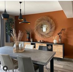 a dining room with orange walls and chairs