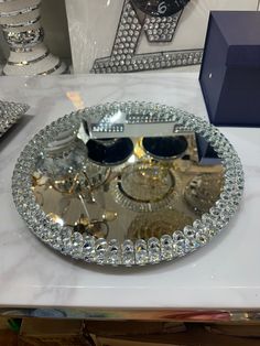 a pair of sunglasses sitting on top of a silver tray covered in swarong