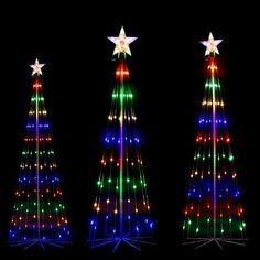 three christmas trees are lit up with colorful lights