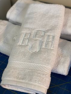 three white towels sitting on top of a cutting board