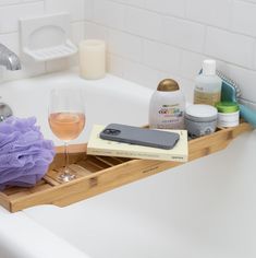 a bathtub with soap, shampoo and other bathroom items on the tub tray