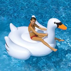 an inflatable pool float with a woman riding on the back of a swan