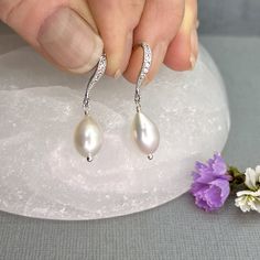 "✦These lustrous white teardrop-shaped natural freshwater pearls earrings are the perfect gift from mom for the Bride-To-Be for her wedding day, or from the bride for her special bridesmaid or maid of honor.   ✦Natural freshwater pearls are creamy white, high quality, and lustrous, measuring 10 x 7mm. ✦They come with your choice of CZ lined leverback ear wires, or beautiful shapely hook ear wires.  Both are made of all sterling silver, with tiny cubic zircona stones embedded in the surface. Plea Pear-shaped Pearl Earrings For Formal Occasions, Elegant Pear-shaped Teardrop Earrings As Gift, Pear-shaped Pearl Drop Bridal Earrings In White Gold, Formal Teardrop Pearl Earrings With Elegant Design, Pearl White Pear-shaped Teardrop Earrings For Formal Occasions, Formal Teardrop Pearl Earrings, Formal Pearl Teardrop Earrings, White Gold Pearl Drop Bridal Earrings As Gift, White Gold Pear-shaped Teardrop Earrings For Wedding