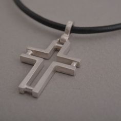 Minimal line and ingenious design characterize this beautiful sterling silver cross pendant necklace for men or women. The effect is minimalistic, yet alluring. Suspended from a silver chain or leather cord with silver clasp and endings, it is a stylish accessory for anyone that wants to keep their faith close to their heart and share it for the world to see. This also makes a stunning Christian gift for a special person in your life. Cross measures 3.8 cm x 2 cm. You get the cross with a 48 cm Modern Silver Necklace With Cross Pendant, Modern Crucifix Cross Necklace As Gift, Minimalist Sterling Silver Cross Pendant Necklace, Modern Sterling Silver Cross Pendant Jewelry, Modern Sterling Silver Cross Pendant, Modern Silver Cross Pendant Necklace, Modern Crucifix Necklace As Gift, Modern Cross Pendant Necklaces As Gift, Modern Cross Necklace As A Gift