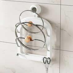 a white wall mounted holder with scissors and hair clips