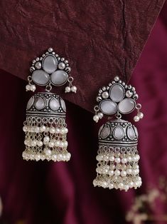 Introducing our exquisite white Statement Jhumkas with Stone Work - a dazzling fusion of tradition and contemporary elegance. These high-quality earrings are meticulously crafted to add a touch of glamour to any outfit, making them the perfect accessory for special occasions or everyday wear. Crafted with precision and attention to detail, these jhumkas are not just stunning but also exceptionally lightweight. You can enjoy the glamour of statement earrings without compromising on comfort. The lightweight design makes them perfect for extended wear, allowing you to dance the night away or confidently carry them throughout your daily activities. Whether you're attending a wedding, a festive celebration, or simply looking to elevate your style, these White Statement Jhumkas with Stone Work a White Intricate Design Drop Earrings, White Intricate Drop Earrings, White Intricate Dangle Jewelry, White Chandbali Fusion Earrings, Traditional White Bridal Earrings As Gift, Fusion Style Jhumkas For Wedding And Navratri, White Chandbali Fusion Jewelry, White Intricate Design Dangle Earrings, Fusion Style Wedding Jhumkas For Navratri