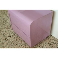 a pink box sitting on top of a floor next to a wall