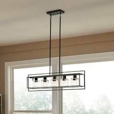 a kitchen light hanging from the ceiling over a table and chairs in front of a window