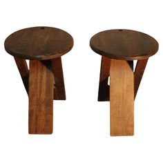 two wooden stools sitting side by side on top of each other in front of a white background