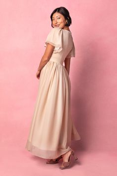 The Abbie Dress in Champagne features princess seams and a subtle sweetheart neckline, making it the perfect bridal party dress. The soft champagne base color is complemented by a maxi length skirt with functional pockets, while the short flutter sleeve adds a touch of femininity. With a hidden back zipper and lining throughout, this dress provides both style and comfort. Fabric with some stretch ensures a perfect fit every time. Dark Champagne Dress, Champagne Maternity Dress, Chiffon Champagne Bridesmaid Dresses, Champagne Bridesmaid Dresses Modest, Flowy Short Sleeve Maxi Dress For Wedding Guest, Bridesmaid Maxi Dress With Pleated Bodice For Prom Season, Short Sleeve Maxi Dress With Pleated Bodice For Wedding, Bridesmaid Dress With Pleated Bodice And Short Sleeves, Wedding Maxi Dress With Pleated Bodice And Short Sleeves